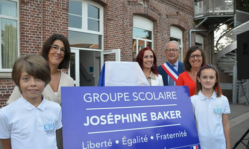 Photo représentant deux élèves tenant un panneau du groupe scolaire Joséphine Baker lors de l'inauguration du groupe scolaire